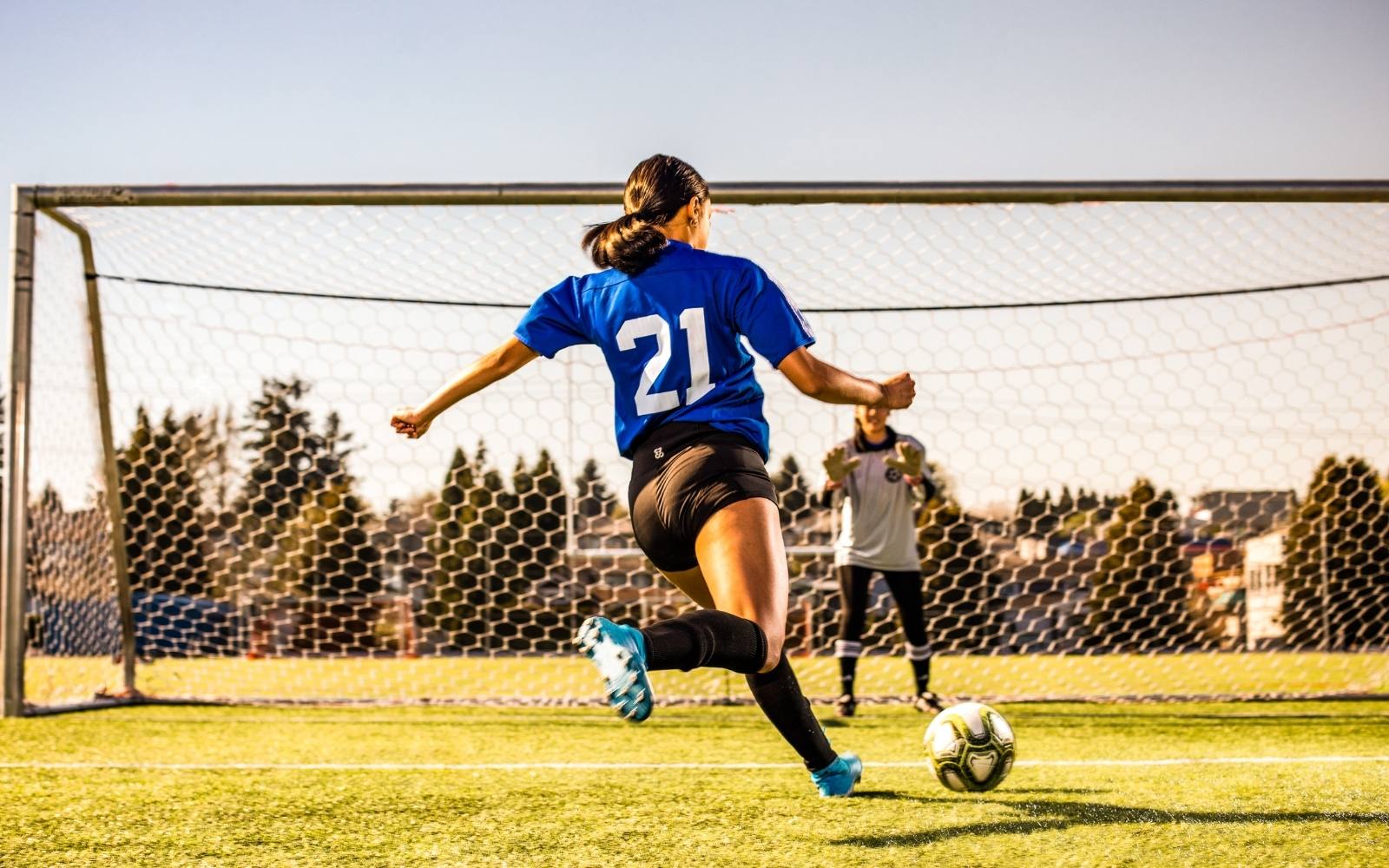 Girl wearing black Flow 2 Freedom exhale shorts and kicking soccer ball
